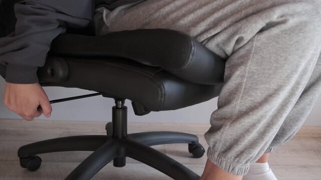 Adjusting office chair height with lever, person sitting and finding comfortable position, simple home lifestyle