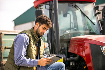 Young tractor driver using tablet beside tractor © Mediteraneo