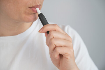 Woman smoking tobacco heating system. Electronic cigarette.