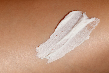 Close-up of a womans skin with a smear of exfoliating body scrub