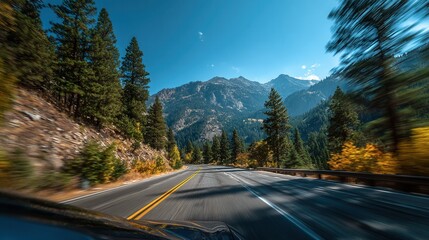 Fototapeta premium Driving view on forest highway with distant mountains and motion blur