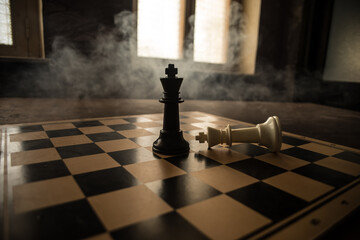 Chess board game concept of business ideas and competition and strategy ideas concep. Chess figures on a dark background with smoke and fog. Selective focus