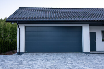 Designer entrance gate to garage. Modern design. Luxurious exterior. Facade of a modern garage.