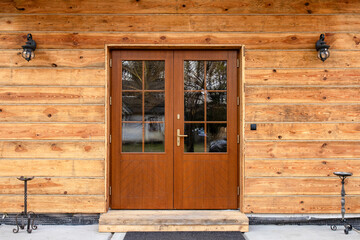 Designer entrance door to a country house. Modern design. Luxurious exterior. Facade of a modern building with modern doors.