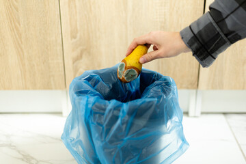 Throwing spoiled pear with mold into blue trash bag