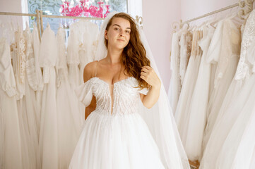 An elegant, beautiful white wedding dress on a bride in a bridal boutique