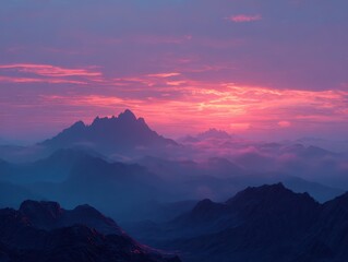 Majestic mountain range basks in the warm glow of sunrise. The sky is awash in hues of pink and purple as the clouds are illuminated by the sun.