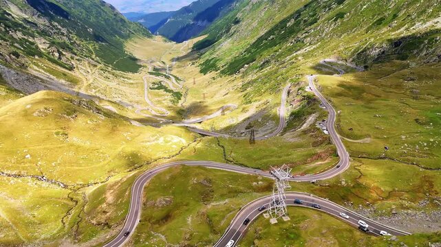 View on the famous Transfagarash highway in the Carpathian Mountains, Romania. Cars move slowly by the wriggly road. Aerial perspective.