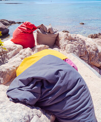 Seaside relaxation : Colorful beanbags invite relaxation by the tranquil turquoise sea, offering a perfect spot to unwind and soak in the sun. 
