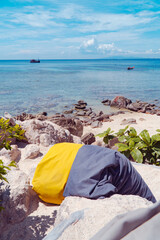 Serene Beach Scene with Leisure Beanbag: A vibrant beanbag invites relaxation on a pristine beach. The clear turquoise water and bright sky create a picturesque backdrop. A tranquil haven for leisure.