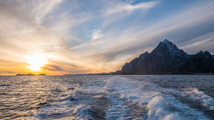 Sonnenuntergang auf dem Meer mit K&uuml;ste der Lofoten
