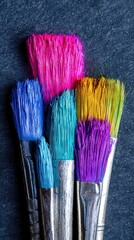 Closeup of Colorful Paintbrushes RGB Paint on a Dark Surface