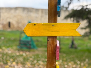 Yellow wooden arrow sign on post outdoors. Symbol of direction, guidance and creative navigation. Copy space and empty space
