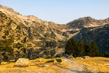 Panoramic view of Lake Aubert at sunrise, reflecting the mountains of the Néouvielle Nature Reserve