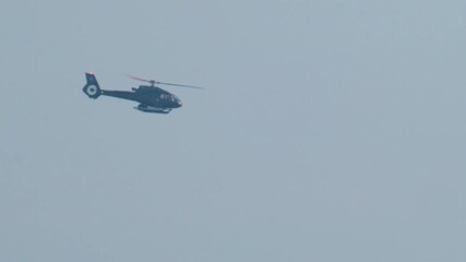 Cannes, France - October 11, 2025: Two workers wearing protective white suits and respirators sand and repair the hull of a boat in dry dock