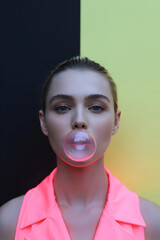 Bubblegum Beauty: Woman Blowing Pink Bubble against Neon Background