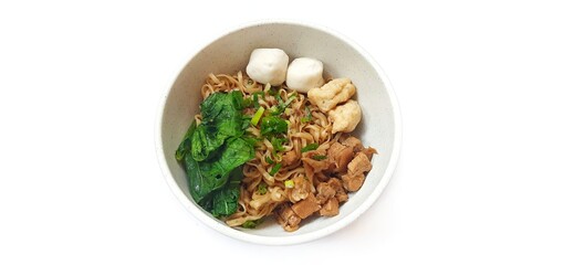 Mie Ayam Indonesian Chicken Noodle Soup with Fish Balls in a Bowl Isolated on White Background....
