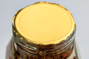 Sealed glass jar filled with instant coffee granules against a light background