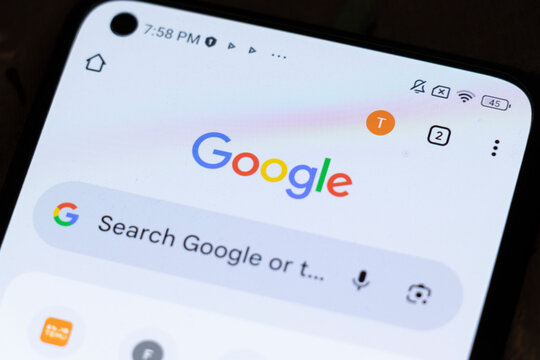 Warsaw, Poland - November 3, 2025: Close-up of a smartphone screen displaying the Google logo with search bar and app icons, illustrating internet browsing activities.