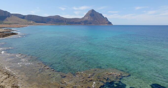 Panorama of Cofano Mount located in the province of Trapani, Sicily, Italy. A mountain in the background and the turquoise sea in the foregroun