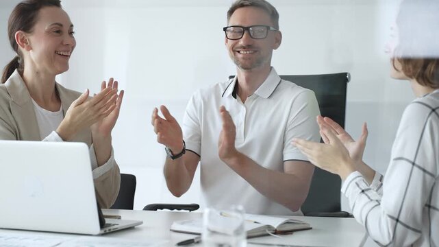 Professional team applauding, celebrating collaborative success and recognizing outstanding performance during corporate meeting, expressing shared workplace achievement