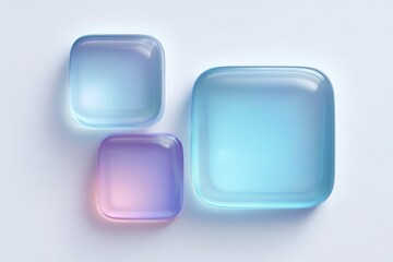 Three distinct, glossy, rounded-square glass objects with vibrant blue and purple gradients on a soft white background, a modern abstract design.