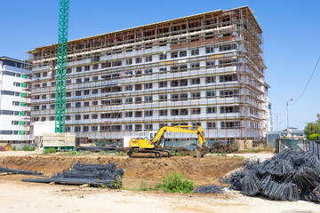 Construction of a new residential area with apartment buildings using construction equipment.