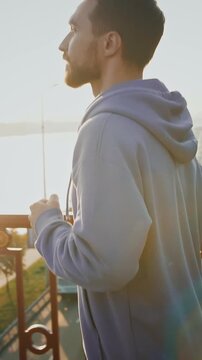 Active lifestyle. Profile of sporty man running on city bridge early in morning, slow motion