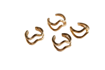 Four shiny golden ear cuffs with a modern, wavy double-band design. Elegant, minimalist jewelry against a solid dark transparent background. background removed