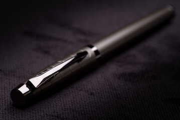 Fototapeta premium Fountain pen, beautiful details of a fountain pen on a black surface, low key photo, selective focus.