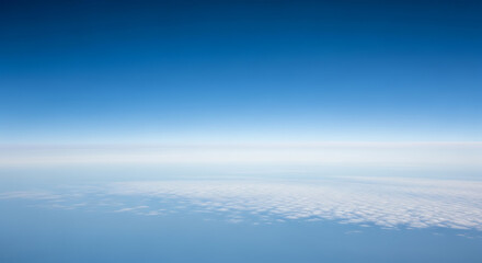 Vast blue sky above white clouds seen from airplane atmosphere