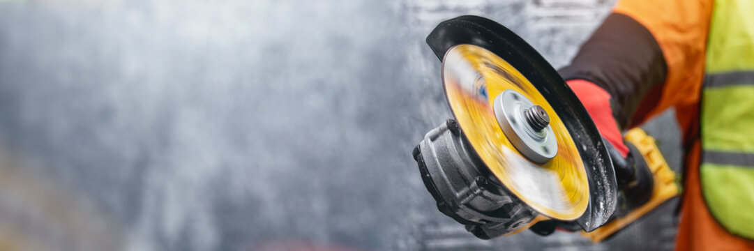 Close-up of a construction worker using an angle grinder with a fast-spinning cutting disc. Protective gloves and safety clothing, symbolizing industrial power. - Powered by Adobe
