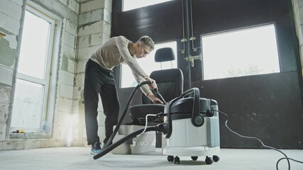 Skilled cleaner rejuvenates worn-out car seat using vacuum cleaner. Experience the satisfaction of seeing dirt vanish and freshness return. Person carefully cleans car seat. 4K, UHD