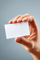 Obraz premium Hand holding a blank card against a blue background