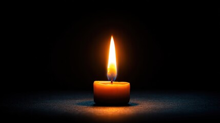 A solitary candle emits a warm, flickering flame against a dark background, creating a serene and contemplative atmosphere.