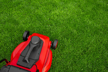 Fototapeta premium Red and black lawn mower on the lawn.