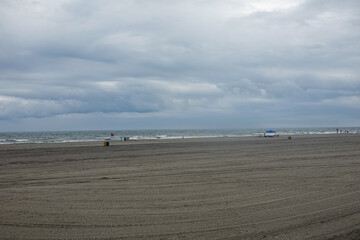 Large almost empty beach with storm clouds over the ocean