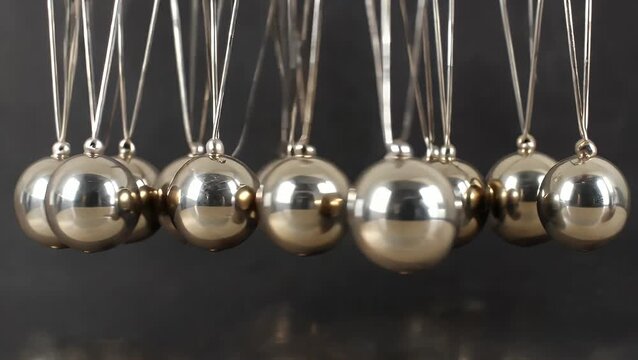 Photograph of Metallic Newton's Cradle Apparatus Demonstrating Principles of Kinetic Energy  Physics  and Momentum Often Used as a Visual Metaphor for Leadership and Chain Reaction