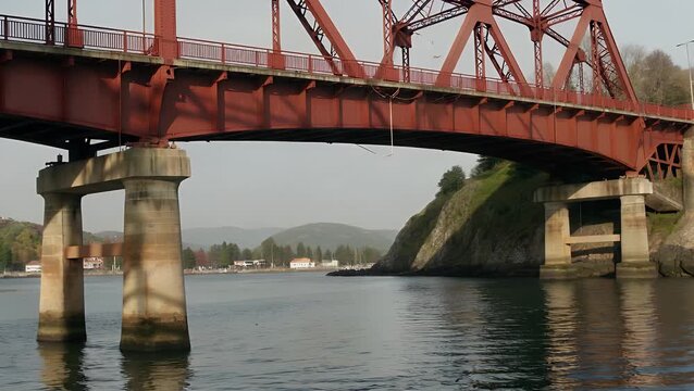 The  Distinctive Shadow Patterns Cast by the Structural Girders of a Prominent Crimson-Colored Bridge Located in a Coastal