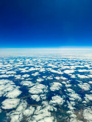 Blue sky blending with white clouds creates a serene view from above the earth, capturing the...