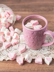Heart-Shaped Pink and White Marshmallows Scattered near a Pink Cup of Hot Chocolate with Love and Hearts