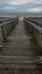 Obraz premium Long wooden boardwalk ramp going towards the ocean