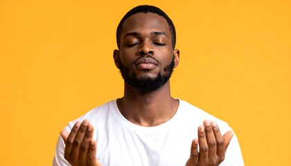 Man in white shirt meditates with eyes closed against a warm yellow background, hands open in a receiving gesture