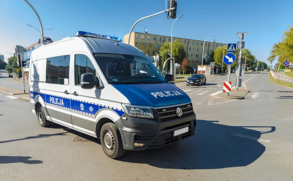 Polska, Ostrowiec Świętokrzyski, 21 września 2025, 14:36. Policyjny furgon Volkswagen ustawiony na skrzyżowaniu  w niebiesko srebrnym malowaniu z napisem POLICJA