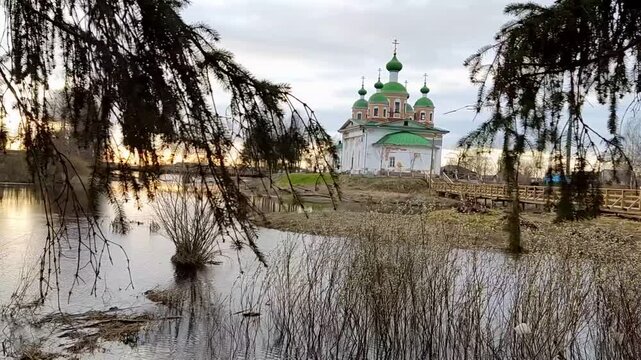 OLONETS, RUSSIA - May 09, 2022: View of the Smolensk Cathedral of the icon of the Mother of God from the side of the river Megrega in twilight