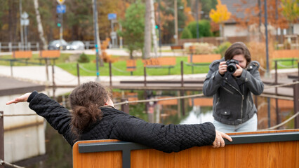 Friends Enjoying a Day at the Park While One Takes Pictures of the Other During Autumn