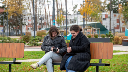 Friends Enjoy a Sunny Day at the Park While Capturing Memories With a Camera and Checking Photos on a Phone