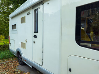 Exploring nature in a cozy camper van during a peaceful afternoon in a scenic park surrounded by vibrant trees