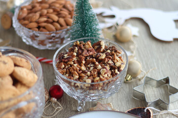 Various Christmas decorations, cookies, chocolate and nuts on wooden background. Selective focus.