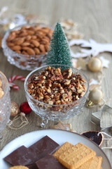 Various Christmas decorations, cookies, chocolate and nuts on wooden background. Selective focus.